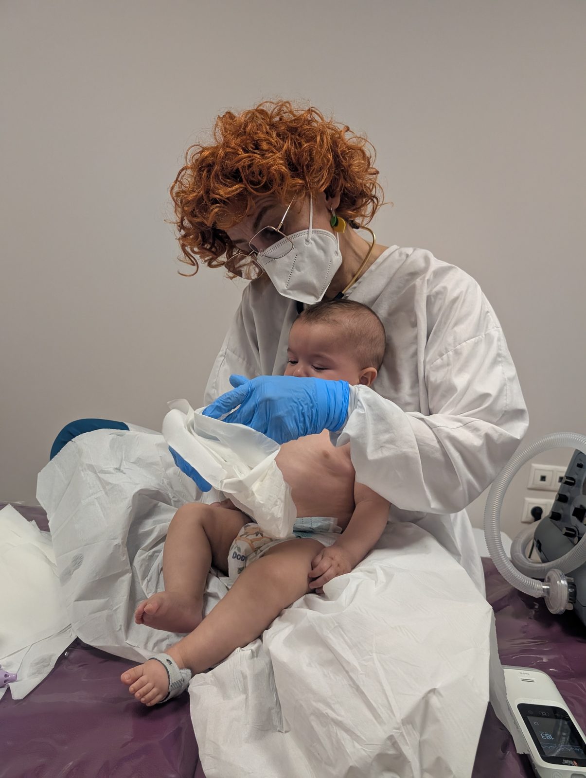 Fisioterapia respiratoria a un bebé en brazos de la profesional