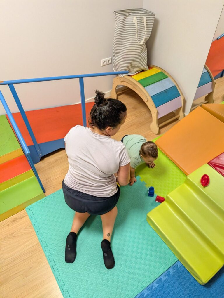 Niño subiendo una rampa acompañado por la fisioterapeuta