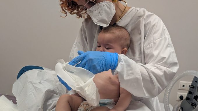 Fisioterapia respiratoria a un bebé en brazos de la profesional