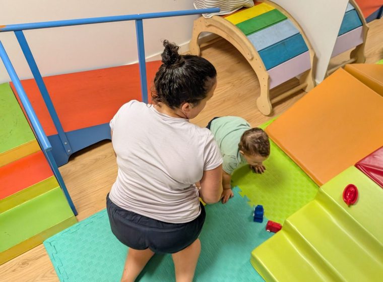 Niño subiendo una rampa acompañado por la fisioterapeuta