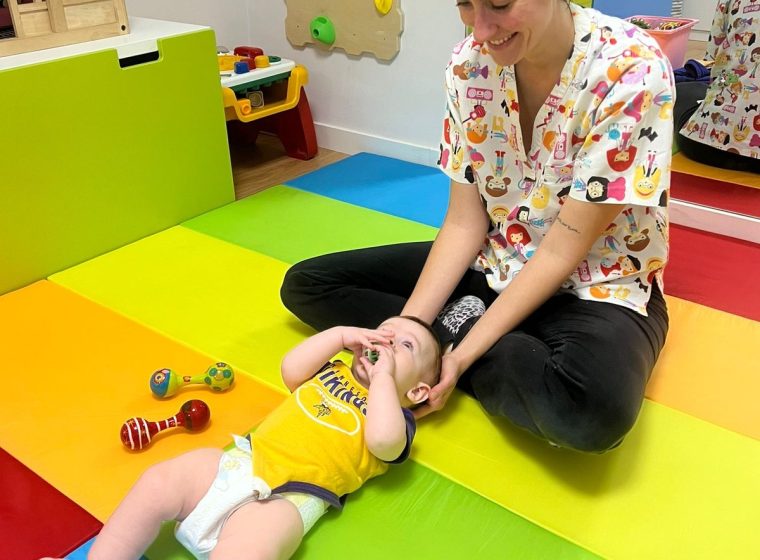 Fisioterapeuta trabajando con un bebé en la sala de fisioterapia pediátrica